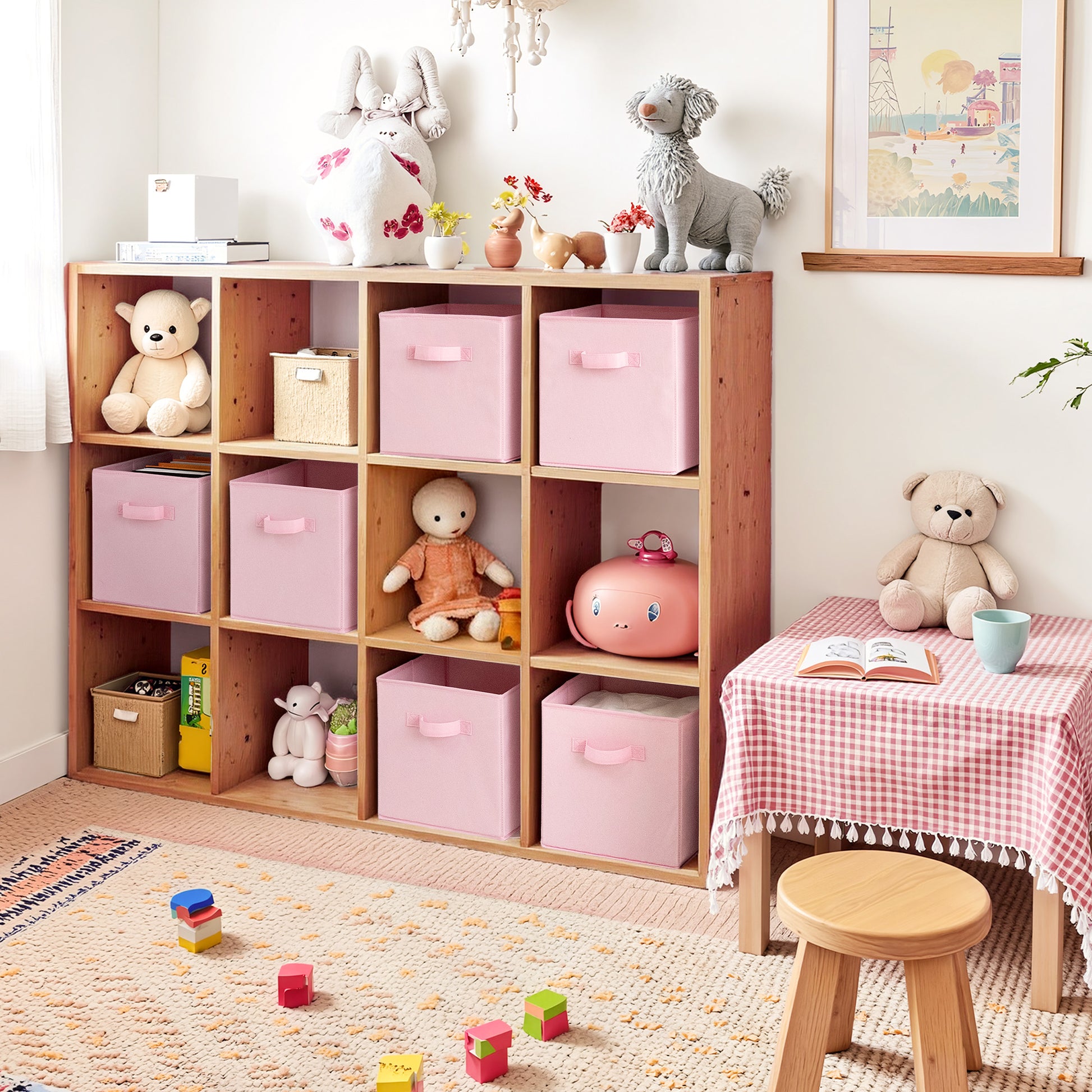 Children's room with wooden storage unit with pink storage bins, toys, and a small table with a teddy bear.